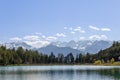 Lake Coredo surface, green forest and alpine mountain peaks covered with snow and ice on a clear spring day,ÃÂ Trentino, Italy Royalty Free Stock Photo